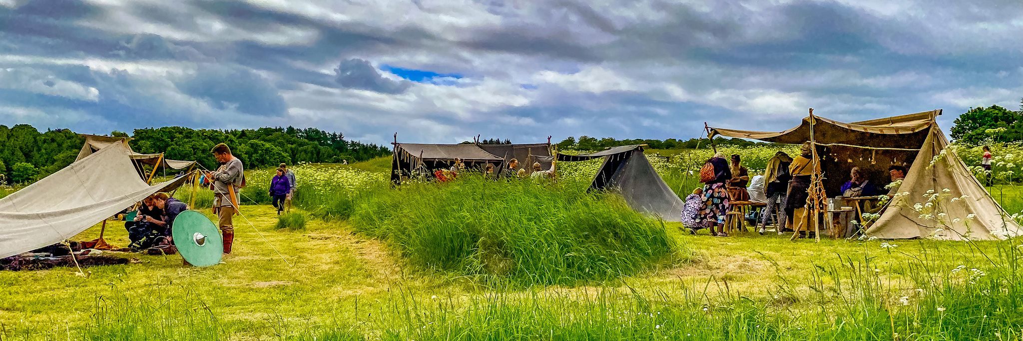 Telte med jernalderhåndværkere på græsmark